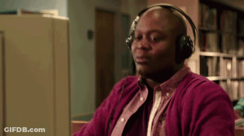 A Bald Man Wearing Headphones Is Sitting In Front Of A Computer . GIF