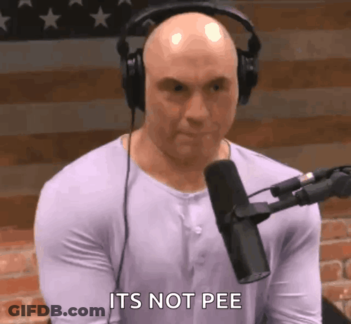 A Bald Man Wearing Headphones Is Sitting In Front Of A Microphone And Says It 'S Not Pee . GIF