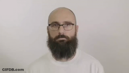 A Bald Man With A Beard And Glasses Is Wearing A White Sweater . GIF