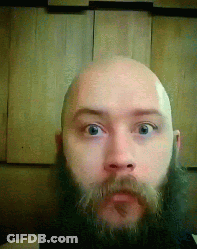 A Bald Man With A Beard And Mustache Is Looking At The Camera GIF