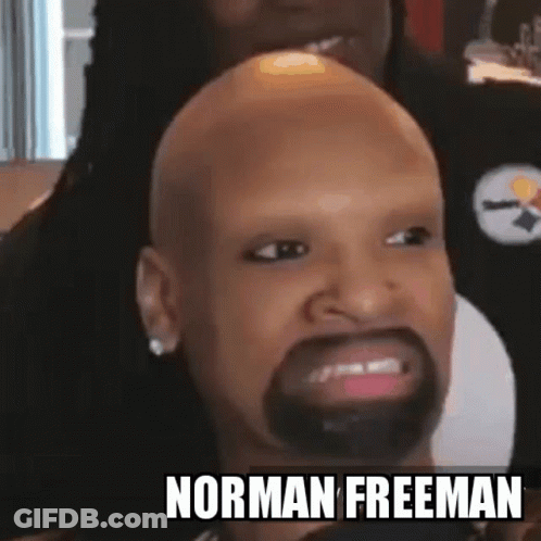 A Bald Man With A Beard And The Name Norman Freeman On The Bottom Right GIF