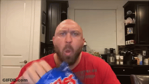 A Bald Man With A Beard Is Eating A Bag Of Lays Chips GIF