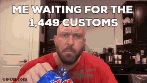 A Bald Man With A Beard Is Holding A Bag Of M&ms GIF