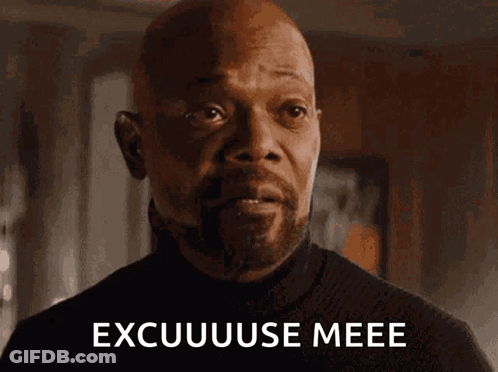 A Bald Man With A Beard Is Looking At The Camera With The Words Excuuuse Meee Written On His Face . GIF