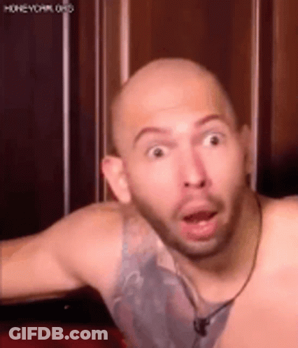 A Bald Man With A Beard Is Making A Funny Face With His Mouth Wide Open . GIF