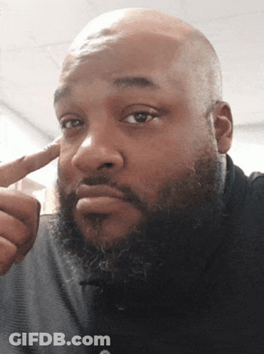 A Bald Man With A Beard Is Pointing To His Forehead GIF