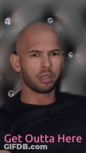 A Bald Man With A Beard Is Sitting In Front Of A Headboard With The Words Get Outta Here On It GIF