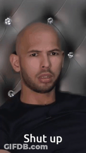 A Bald Man With A Beard Is Sitting In Front Of A Headboard With The Words Shut Up Written On It GIF