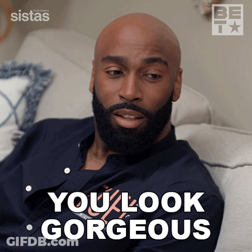 A Bald Man With A Beard Is Sitting On A Couch With The Words You Look Gorgeous Behind Him GIF