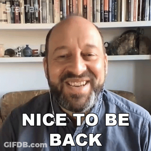 A Bald Man With A Beard Is Smiling And Says Nice To Be Back GIF