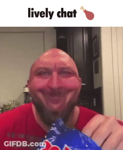 A Bald Man With A Beard Is Smiling While Holding A Bag Of Chicken GIF