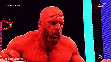 A Bald Man With A Beard Is Standing In A Ring With A Live Sign Behind Him GIF
