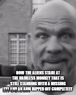 A Bald Man With A Beard Is Standing In Front Of A Building GIF