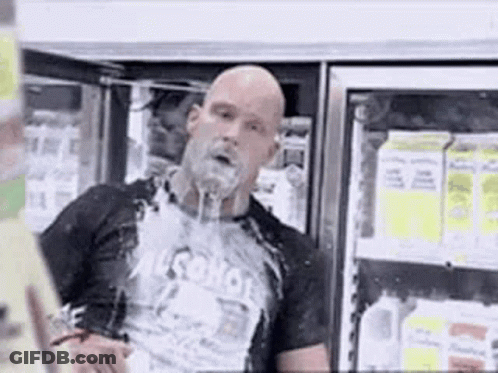 A Bald Man With A Beard Is Standing In Front Of A Refrigerator In A Store . GIF
