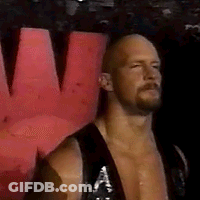 A Bald Man With A Beard Is Wearing A Black Tank Top And Standing In Front Of A Red Wall . GIF