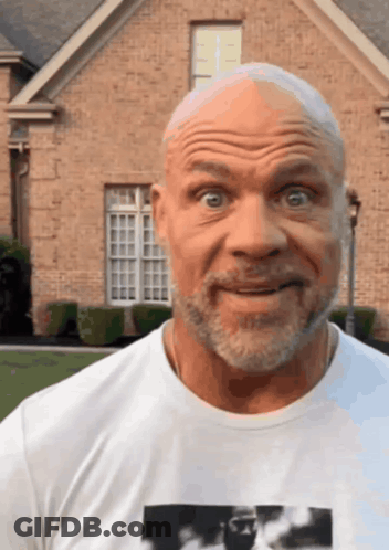A Bald Man With A Beard Is Wearing A White T-Shirt With A Picture Of A Man On It GIF