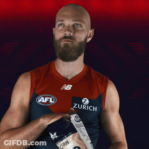 A Bald Man With A Beard Is Wearing An Afl Jersey With Zurich On It GIF