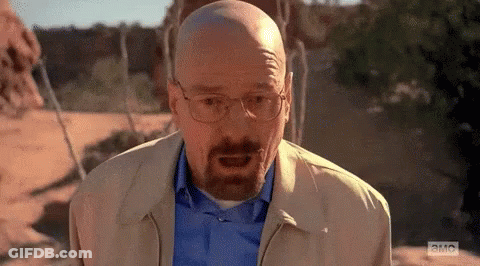 A Bald Man With A Beard Is Wearing Glasses And A Blue Shirt . GIF