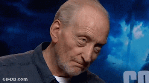 A Bald Man With A Beard Looks At The Camera With A Blue Background With The Letter C On It GIF