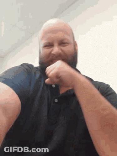 A Bald Man With A Beard Wearing A Black Shirt Is Laughing GIF