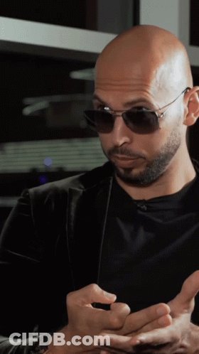 A Bald Man With A Beard Wearing Sunglasses And A Black Shirt GIF