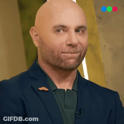 A Bald Man With A Beard Wears A Blue Suit GIF