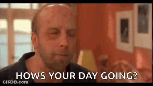 A Bald Man With A Black Eye Is Sitting In A Living Room And Asking Hows Your Day Going . GIF