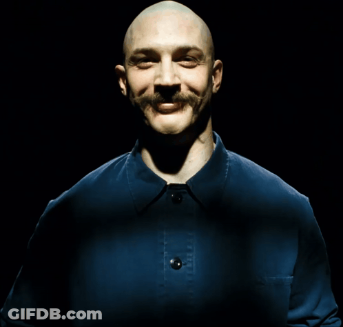 A Bald Man With A Mustache Is Laughing With His Mouth Open GIF