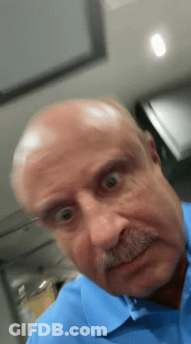 A Bald Man With A Mustache Is Making A Funny Face GIF