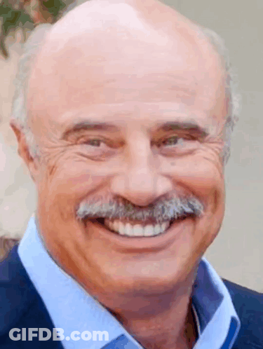 A Bald Man With A Mustache Is Smiling For The Camera . GIF