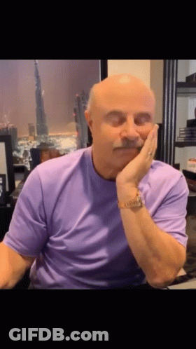 A Bald Man With A Mustache Is Wearing A Purple Shirt GIF