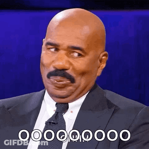 A Bald Man With A Mustache Is Wearing A Suit And Tie And Is Making A Funny Face . GIF