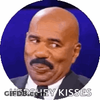 A Bald Man With A Mustache Is Wearing A Suit And Tie And Says Hershey Kisses . GIF