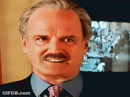 A Bald Man With A Mustache Wearing A Blue Shirt And Tie GIF