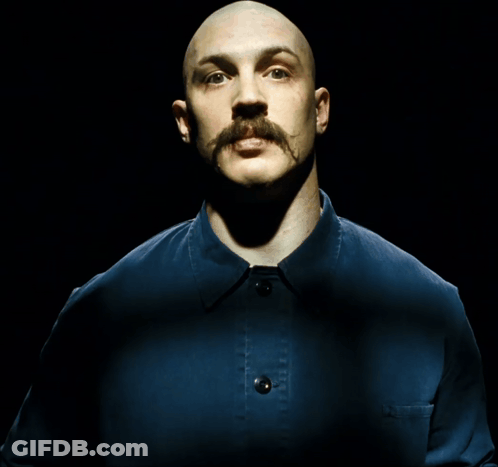 A Bald Man With A Mustache Wearing A Blue Shirt GIF