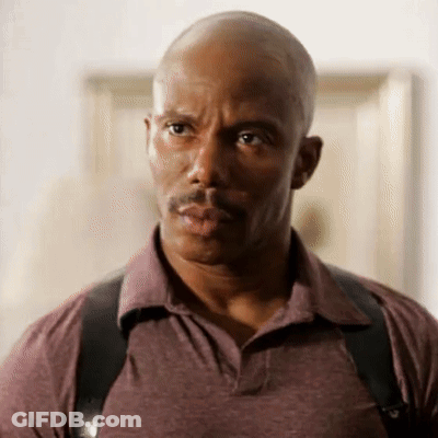 A Bald Man With A Mustache Wearing A Purple Shirt And Black Suspenders GIF