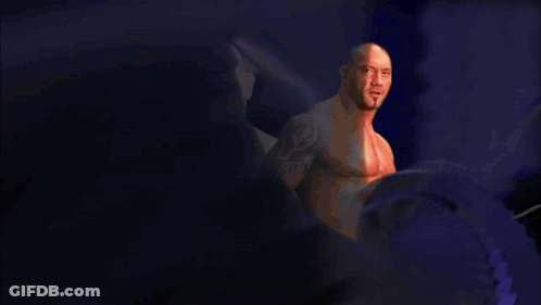 A Bald Man With A Tattoo On His Arm Is Standing In Front Of A Purple Background With The Name Bat On It GIF