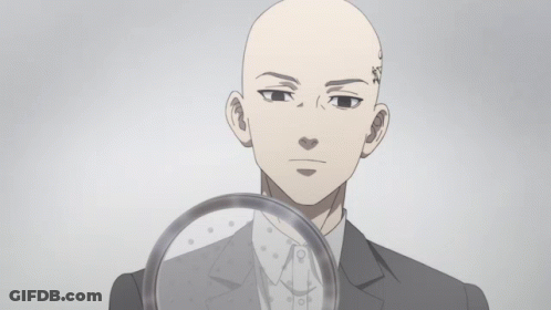 A Bald Man With A Tattoo On His Forehead Is Holding A Magnifying Glass GIF