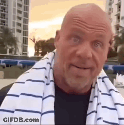 A Bald Man With A Towel Around His Neck Is Smiling . GIF