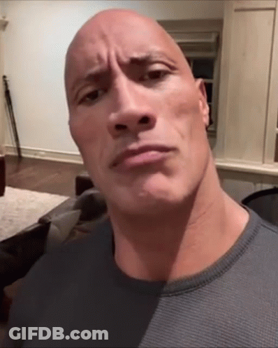 A Bald Man With A Very Large Head Looks At The Camera GIF