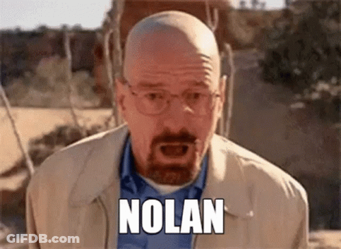 A Bald Man With Glasses And A Beard Is Screaming With The Word Nolan Written On His Face . GIF