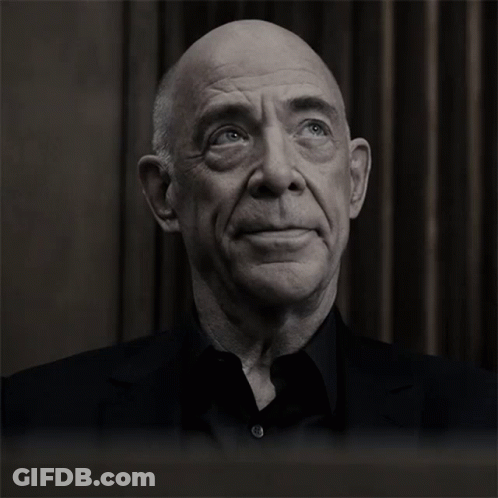 A Bald Man With His Eyes Closed And A Black Shirt GIF