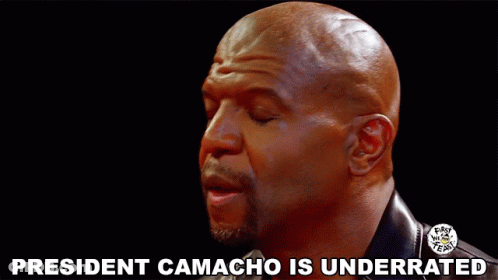 A Bald Man With His Eyes Closed And The Words President Camacho Is Underrated Above Him GIF