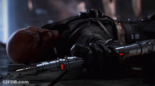 A Bald Man With Red Eyes Is Holding A Red Light Saber GIF