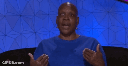 Bald Woman In Blue Shirt Sitting With Outstretched Hands GIF
