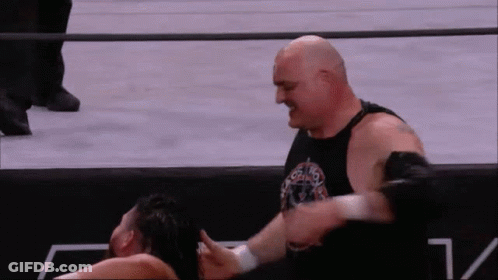 A Bald Wrestler Is Wrestling Another Wrestler In A Ring . GIF