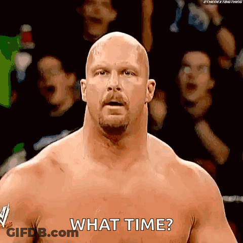 A Bald Wrestler With A Beard Is Standing In Front Of A Crowd And Asking What Time . GIF