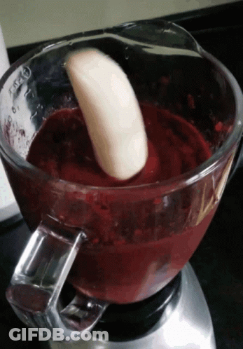 A Banana Is Being Added To A Blender With A Red Liquid GIF