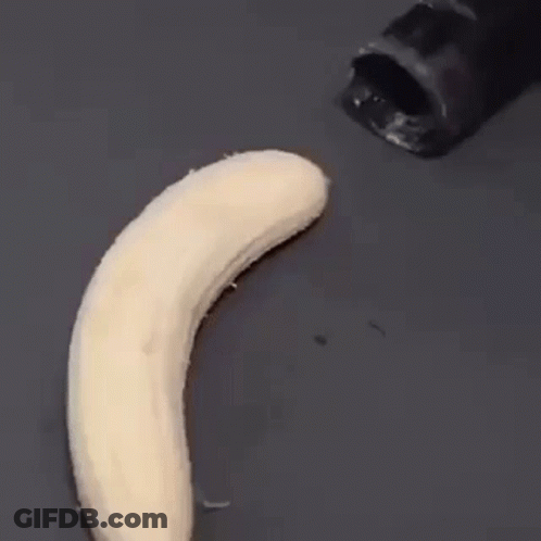 A Banana Is Being Peeled By A Black Knife On A Black Surface . GIF