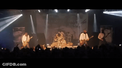 A Band Is Playing On Stage In Front Of A Crowd GIF